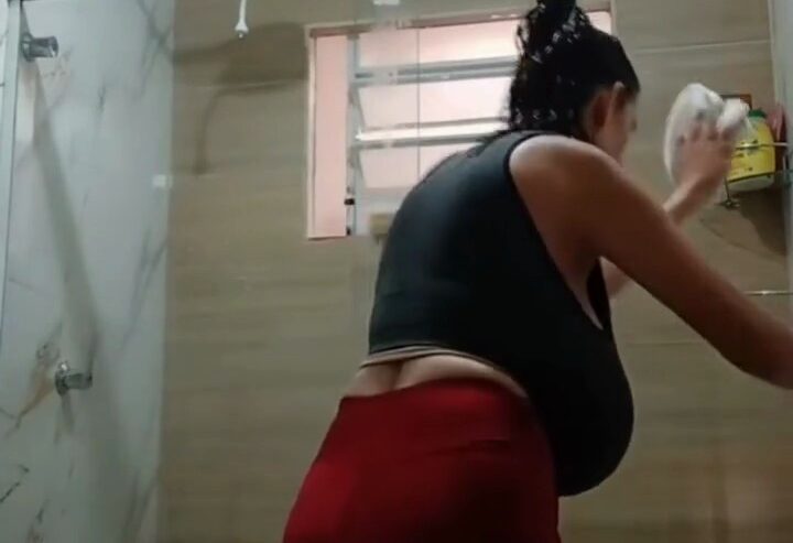 Priscila de Fátima in black top washing the bathroom